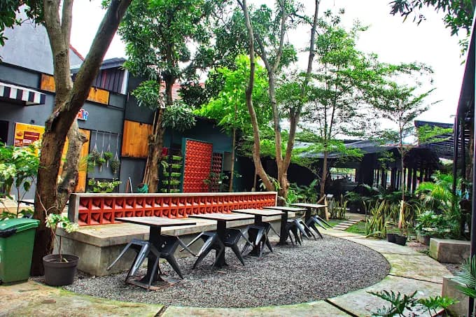 Black exterior with lush green plants at Oksigen Coffee Cirebon